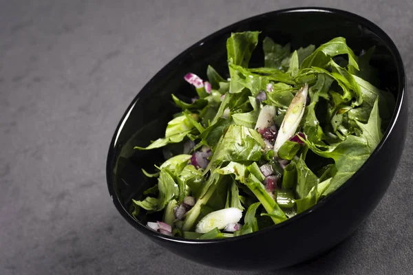 Salat im schwarzen Teller — Stockfoto