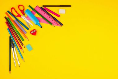 Sarı arka planda okul malzemeleri