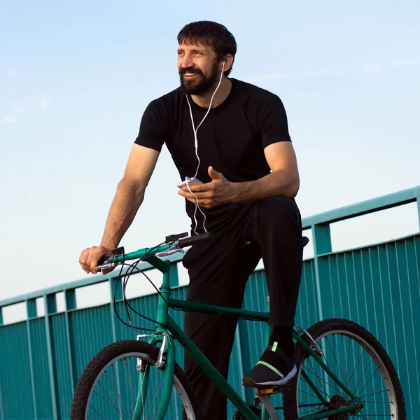 Улыбающийся велосипедист с помощью телефона — стоковое фото