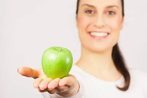 Kvinnan presenterar grönt äpple — Stockfoto