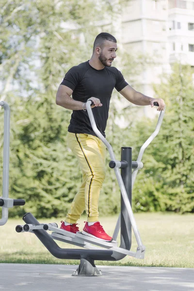 Sportig kille tränar på gym utrustning utomhus — Stockfoto