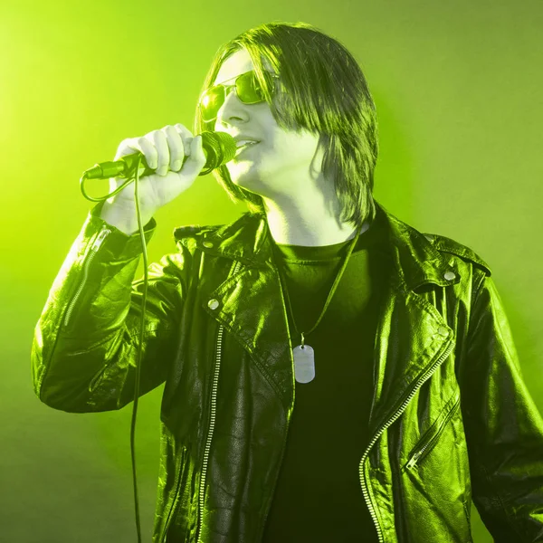 Green illuminated young singer — Stock Photo, Image