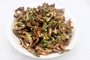 Beyaz tabakta sarımsak soslu sazan balığından kızarmış balık cipsi..