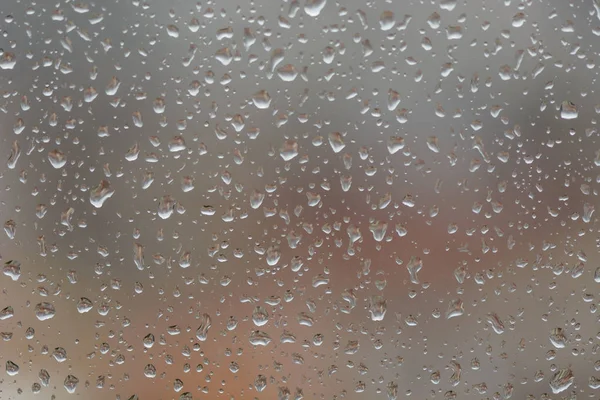 Regentropfen auf Fenster, vor verschwommenem Hintergrund einer Stadt — Stockfoto