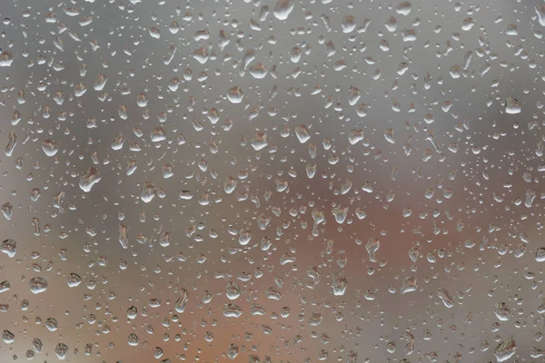 Regentropfen auf Fenster, vor verschwommenem Hintergrund einer Stadt — Stockfoto