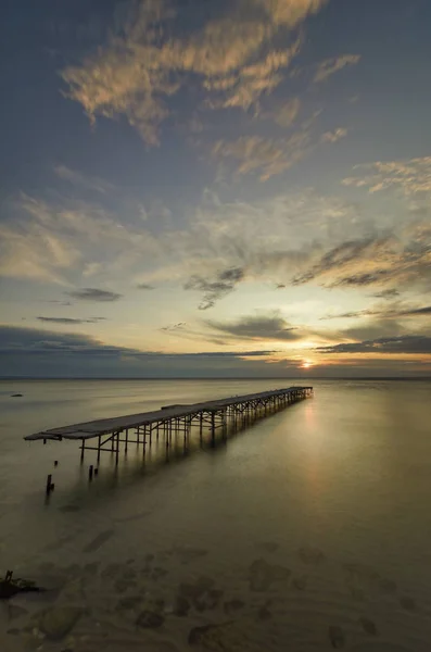 Betong som broken bridge i havet mot en pulserande soluppgång i V — Stockfoto