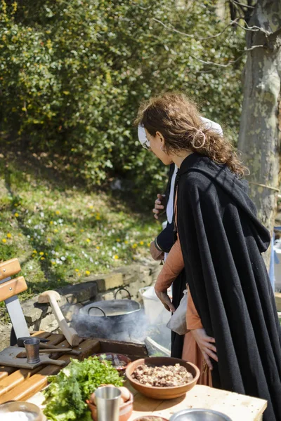 Veliko Tarnovo, Bułgaria, 04 kwiecień 2015, Kobieta z ubrania vintage gotować średniowiecznego posiłku w średniowieczny jarmark w twierdzy tsarevets — Zdjęcie stockowe