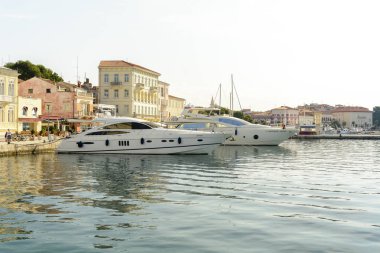 Porec, Hırvatistan, 24 Eylül 2017: Porec Marina iskelede yürüyüş ve lüks yat arayan turist.