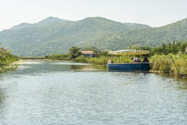 Neretva, Hırvatistan, 30 Eylül 2017: tekne safari neretva Nehri Deltası, mandalina ağacı ve portakal ağacı arasında üzerinde turist ile. geleneksel müzik ve gösteri yapma şarkıcı.
