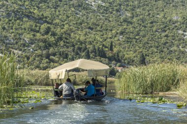 Neretva, Hırvatistan, 30 Eylül 2017: tekne safari neretva Nehri Deltası, mandalina ağacı ve portakal ağacı arasında üzerinde turist ile. geleneksel müzik ve gösteri yapma şarkıcı.