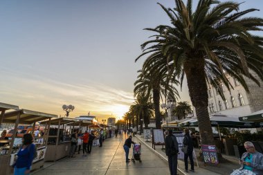Trogir, Hırvatistan, Ekim 01. 2017: bir satın alma ürünler tüccar Merkezi sokakta günbatımında yürüyen turist.