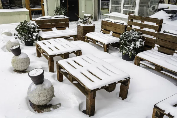 Wooden table and chair covered with snow in Varna, Bulgaria. — Stock Photo, Image