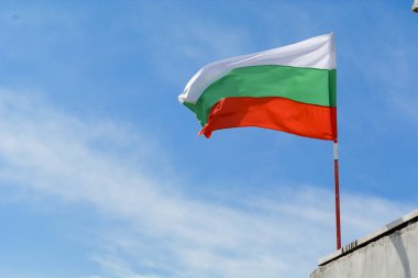 Bulgar bayrak sallayarak karşı canlı mavi gökyüzü.