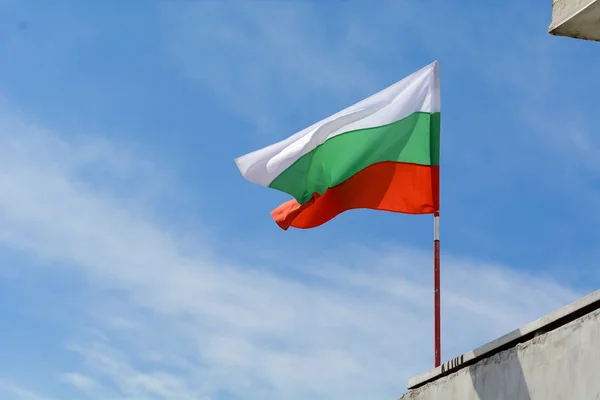 Болгарська прапор махав яскраві блакитному небі. — стокове фото