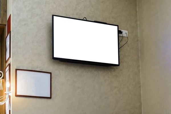 Televisor på en vägg med en tom ram för din annonsering. — Stockfoto