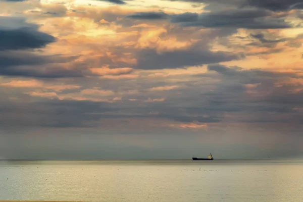 Pequeno petroleiro contra um incrível céu colorido dramático  . — Fotografia de Stock