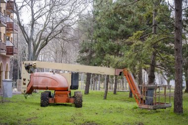 Mafsallı Boom Asansör bir parkta çim.