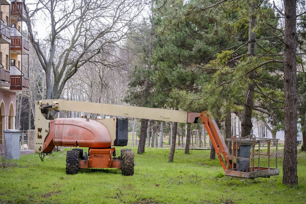 Articulated Boom Lift in the grass in a park.