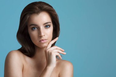 Güzel genç kadın temiz taze cilt ile kendi yüz dokun. Fac