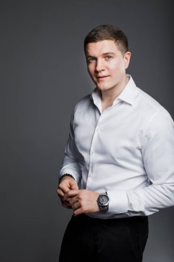 Beyaz adam gri arka planda stüdyoda.