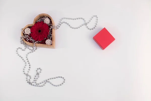 Forma de corazón caja de madera con cuentas y gerberas de flores y bo rojo — Foto de Stock