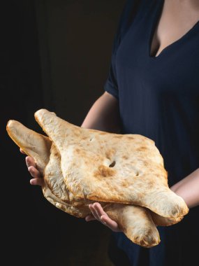 partial view of person holding tasty traditional georgian flatbreads clipart