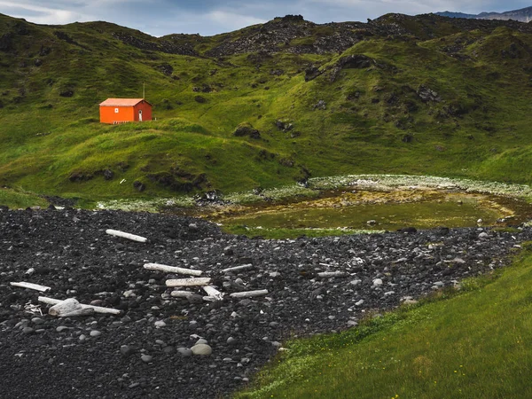 Northern landscape with lone red house in green mountains, Iceland — Stock Photo
