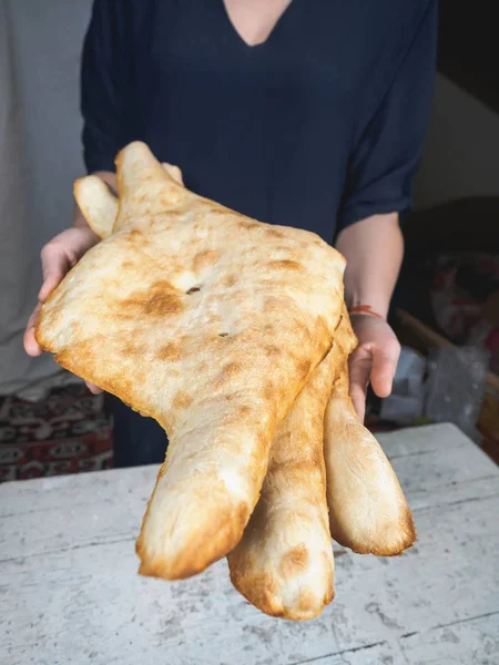 Vue rapprochée de la personne tenant de délicieux pains plats géorgiens traditionnels — Photo de stock