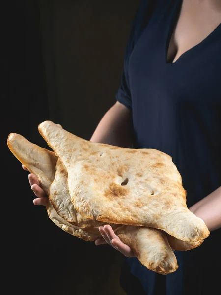 Teilansicht der Person, die leckere traditionelle georgische Fladenbrote hält — Stockfoto