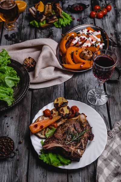 close-up shot of tasty grilled steak with vegetables on gray wooden table