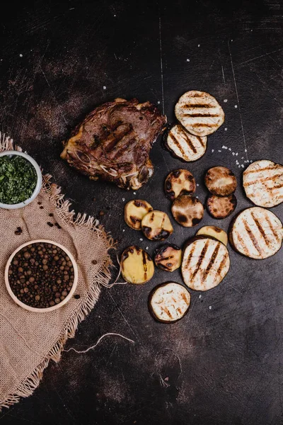 Top view of tasty grilled steak and sliced eggplant on black concrete surface — Stock Image Top View Tasty Grilled Steak Sliced Eggplant Black Concrete Surface Royalty Free Stock Images