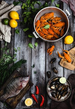 top view of various delicious seafood with lemons and herbs on rustic wooden table  clipart