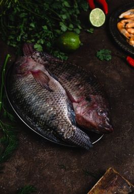 taze çiğ balık limes ve otlar karanlık yüzeyi ile vintage tabakta görmek