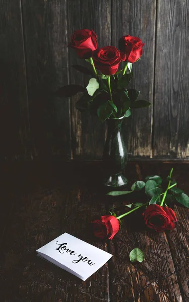 ぼろぼろの木製の背景 バレンタインデー概念上カードの挨拶する花瓶と愛の赤いバラ — ストック写真