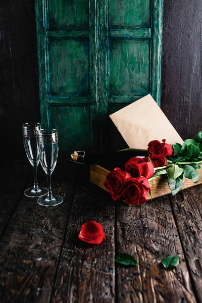 Κόκκινα Τριαντάφυλλα Και Μπουκάλι Σαμπάνιας Γυαλιά Και Φάκελο Στο Δίσκο — Φωτογραφία Αρχείου