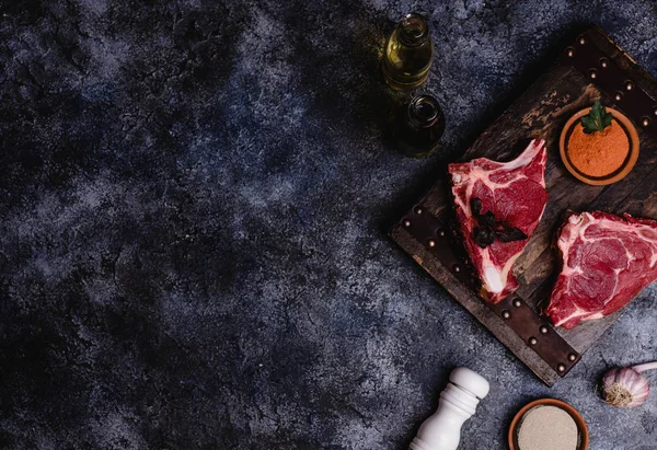 Top view of raw meat on wooden cutting board with spices — Stock Photo