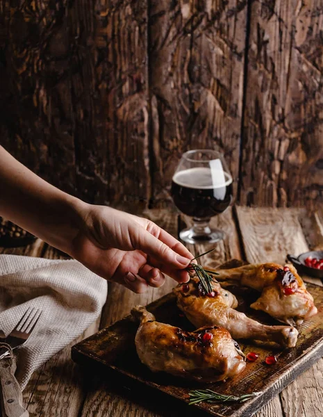 Cropped shot of woman adding rosemary to delicious grilled meat — Stock Photo