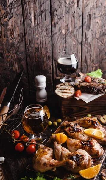 Tasty grilled meat with vegetables and beer on wooden background — Stock Photo