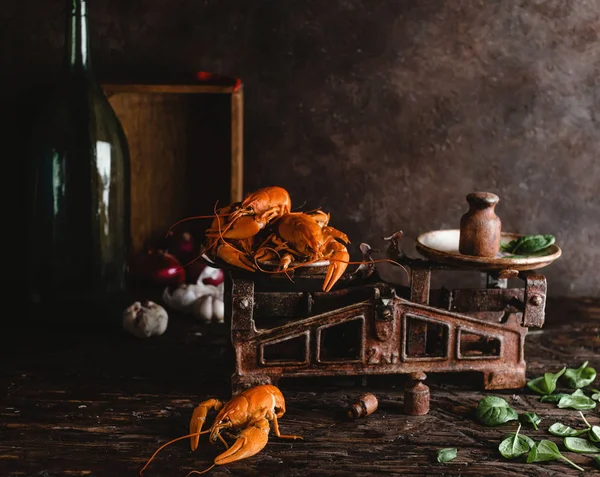 Вид крупним планом смачні омари на старовинних масштабах і листя базиліка на сільській стільниці — стокове фото