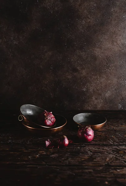 Close-up view of vintage utensils with red onions on rustic wooden table — Stock Photo