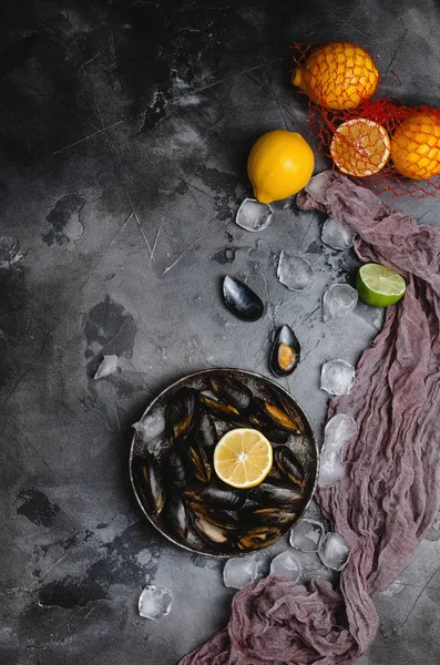 Vista dall'alto di deliziose cozze con conchiglie su piatto vintage e agrumi con cubetti di ghiaccio su grigio — Foto stock