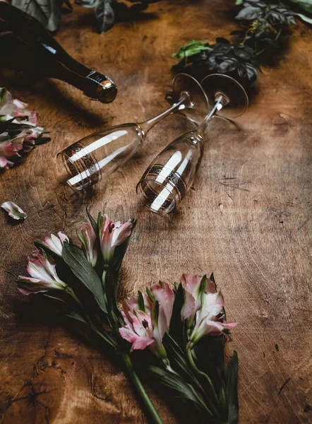 Flores, garrafa de champanhe e copos na mesa de madeira — Fotografia de Stock