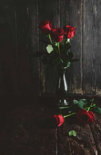 Red rose flowers in vase on shabby wooden background, valentines day concept — Stock Photo