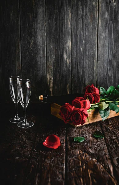 Rosas rojas y botella de champán y vasos en bandeja, concepto de día de San Valentín - foto de stock