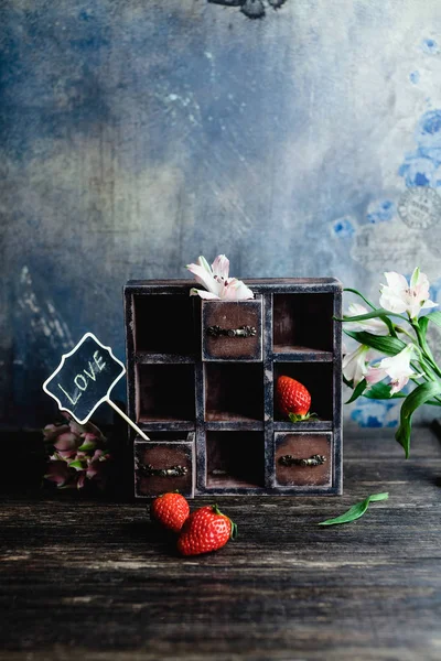 Vintage cabinet with flowers, strawberries and love sign for valentines day — Stock Photo