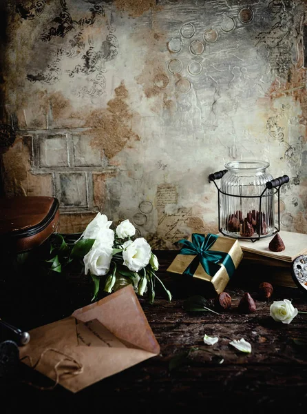 Enveloppe vintage, fleurs d'eustomes, boîte cadeau et bocal en verre avec bonbons au chocolat — Photo de stock