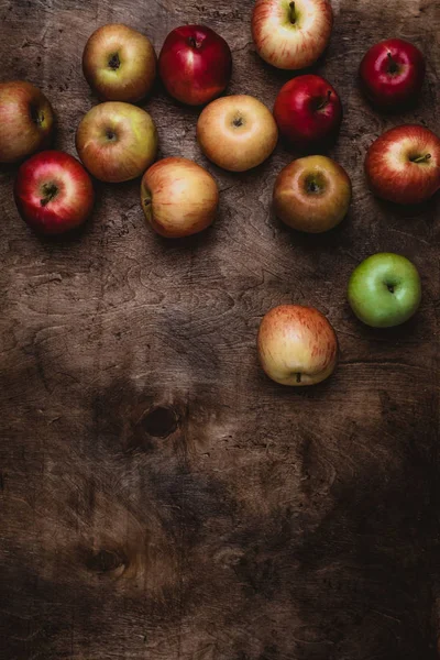 Vista superior de diferentes manzanas en la superficie de madera rústica - foto de stock