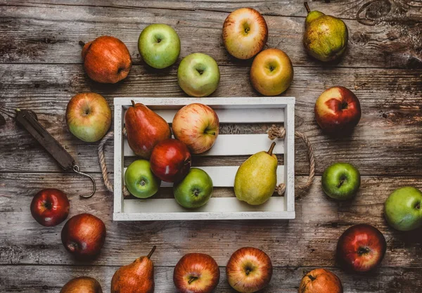 Draufsicht auf Handwaagen, Äpfel und Birnen in Schachtel auf Holztisch — Stockfoto