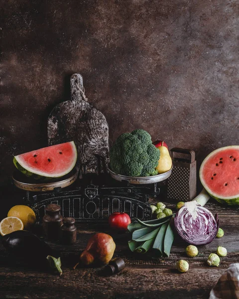 Cutting board, grater, scales, different fruits and vegetables on rustic wooden tabletop — Stock Photo