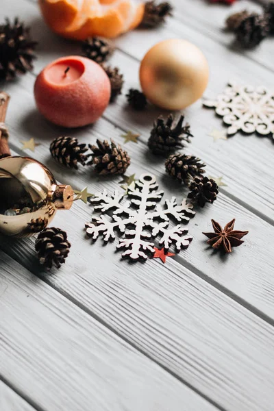 白の木製テーブルの上のクリスマスの装飾と松ぼっくりのクローズ アップ — ストック写真